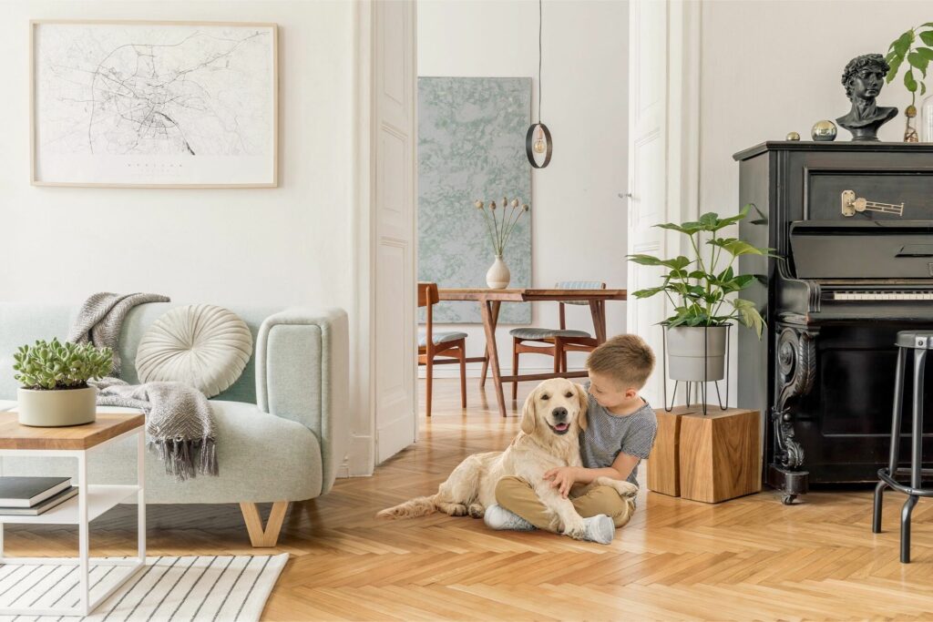 Child sitting with family dog on durable hardwood style flooring in a pet friendly living room